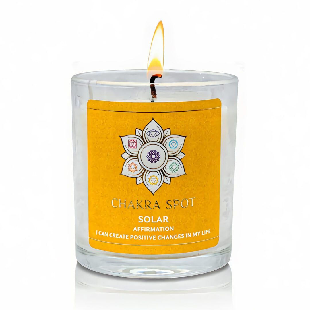 Lit candle with yellow chakra design label.