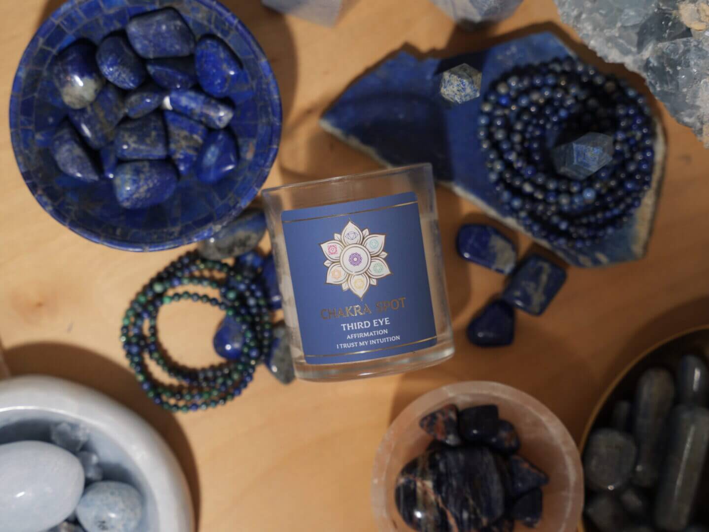 Candles and blue crystals on wooden surface.