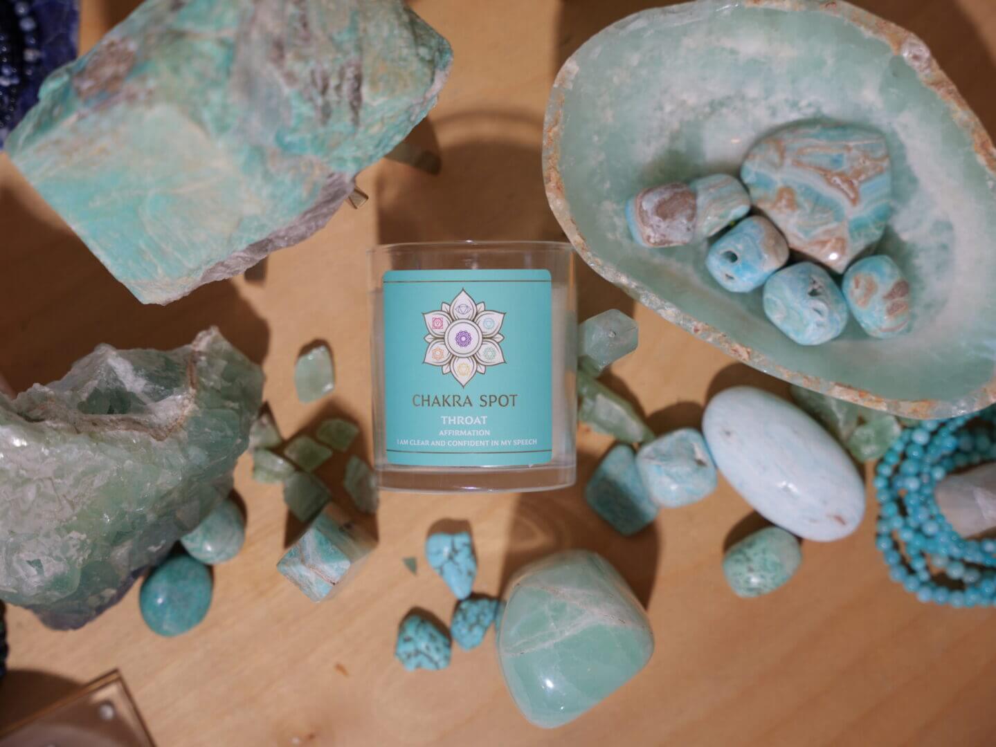 Turquoise stones and candle on wooden surface.