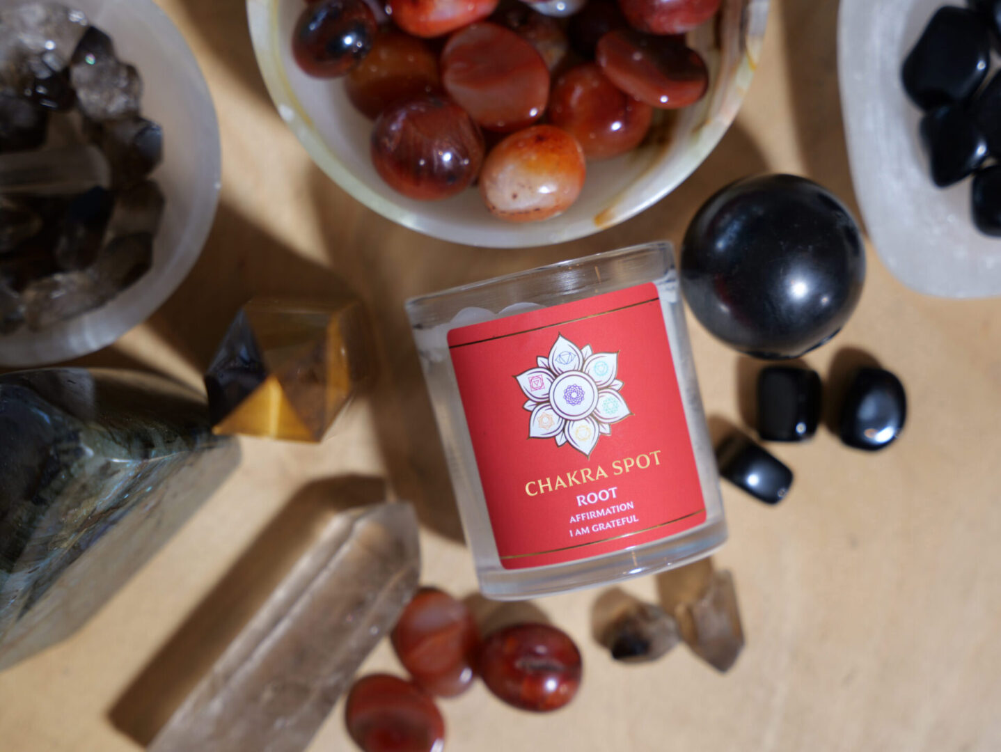 Candle with crystals and gemstones on table.