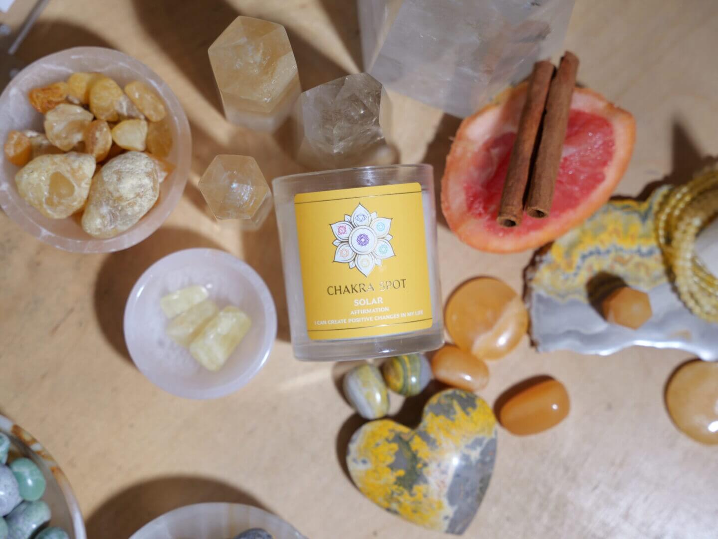 Candle with crystals, citrus, and cinnamon sticks.