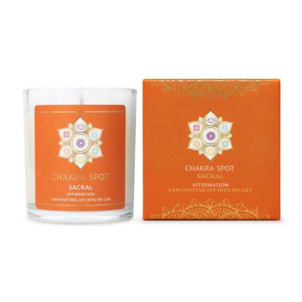 The Chakra Spot Sacral candle is in a glass jar beside its orange gift box